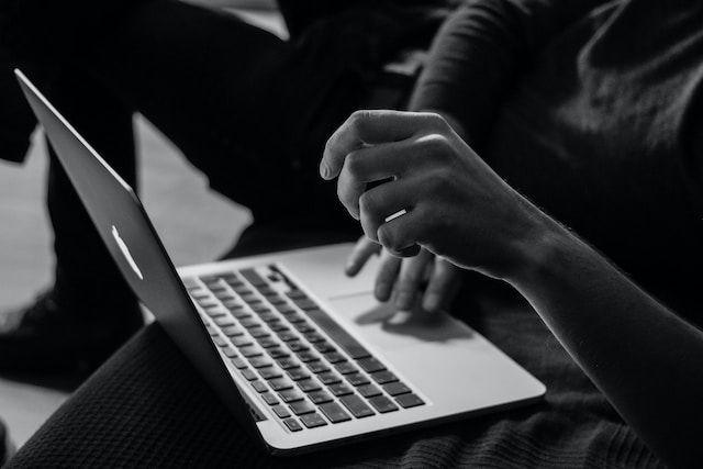foto em preto e branco representando uma pessoa teclando com o notebook no colo pesquisando o que é 4g